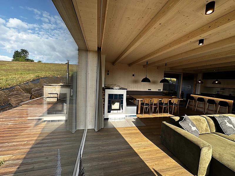 View from the terrace into the living room and the tiled stove