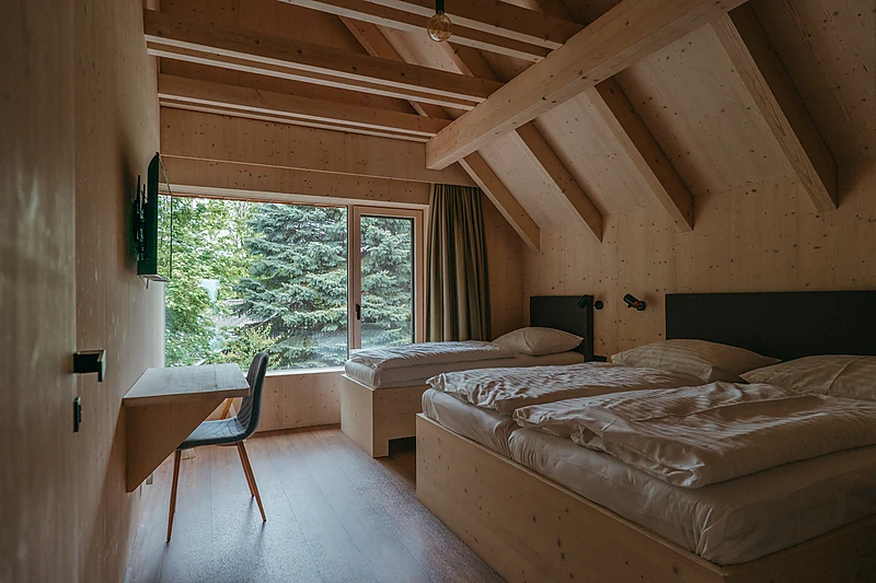 Bedroom with two beds and a view of the greenery