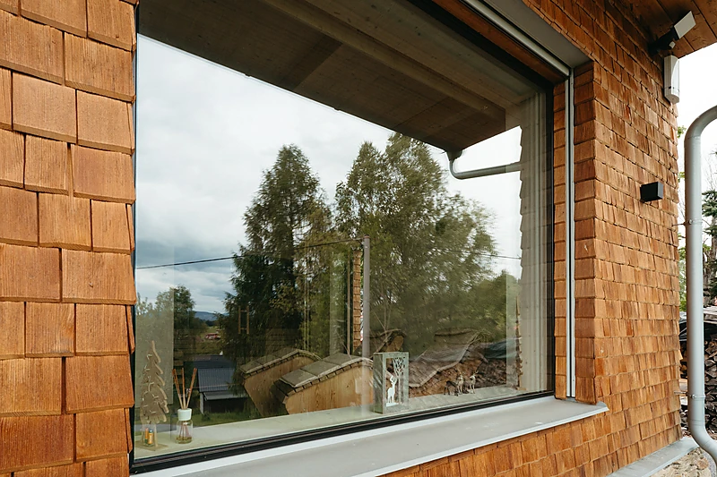 The large living room window in the shingled facade