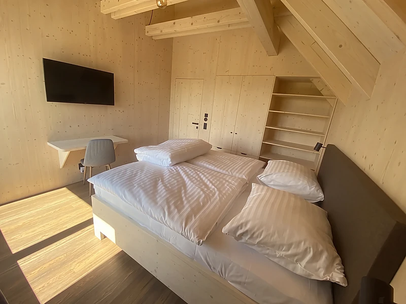 Bedroom under the exposed roof trusses