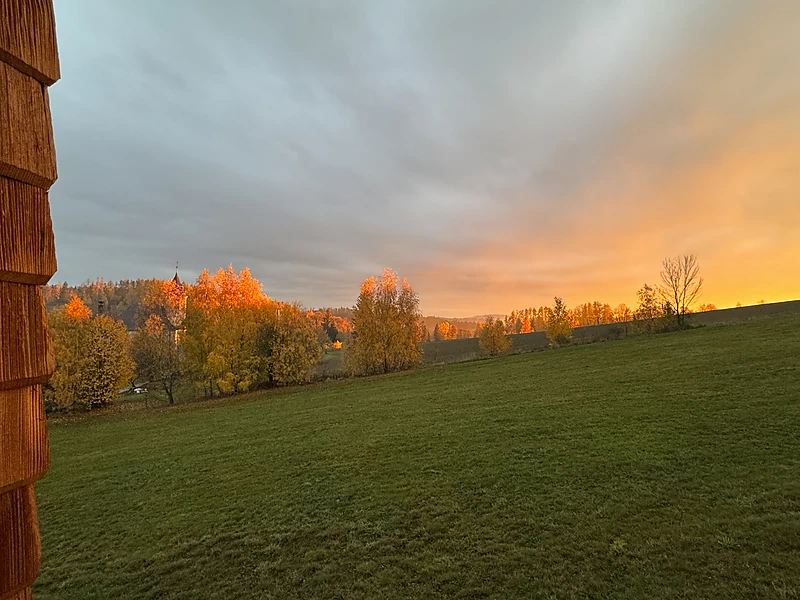 The meadow by the chalet at an autumn sunset