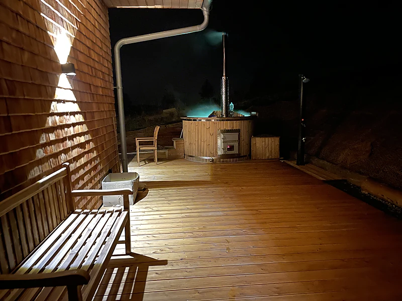 The terrace and the lit hot tub at night